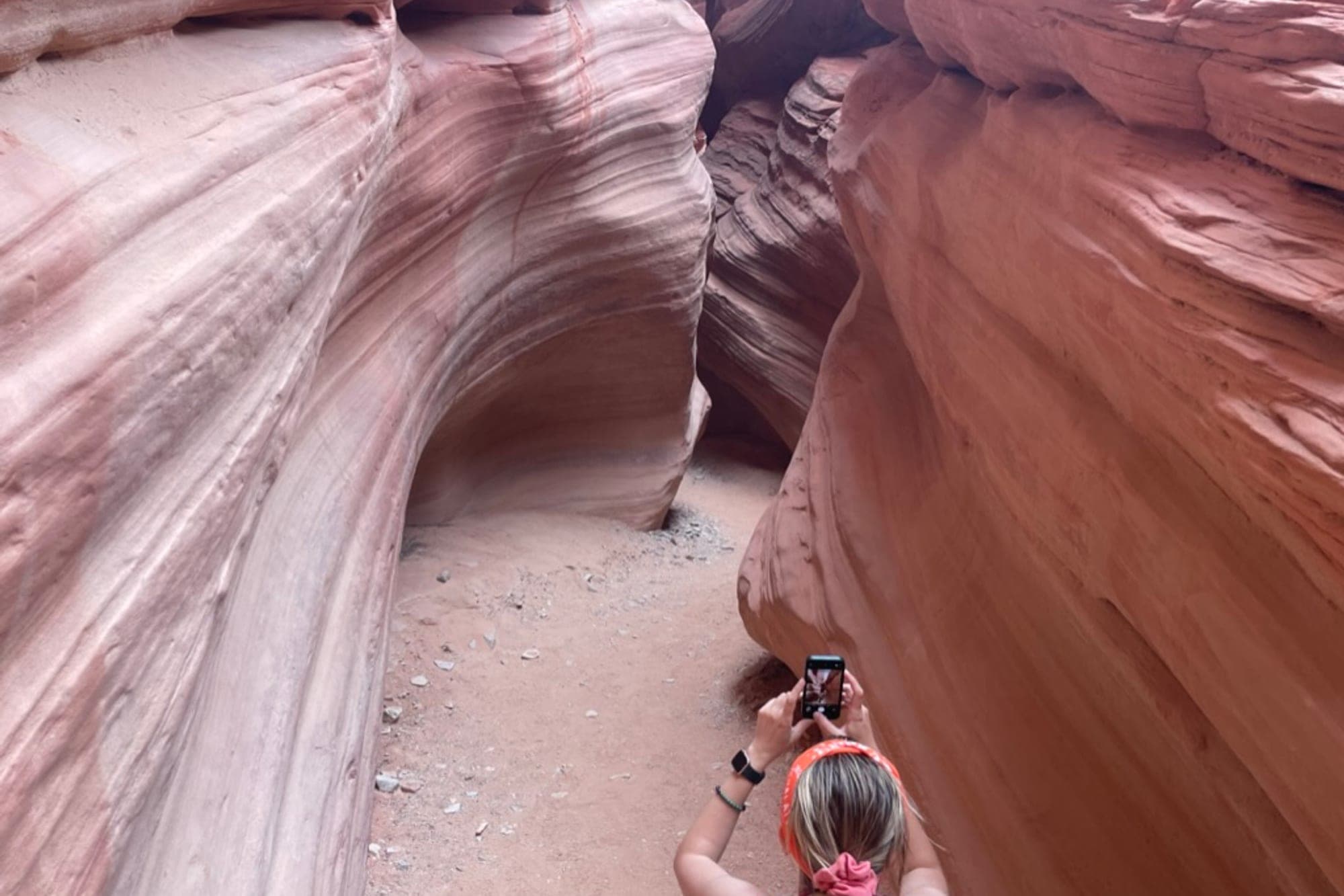 Visitors photographing a sandstone slot canyon on a national park trail